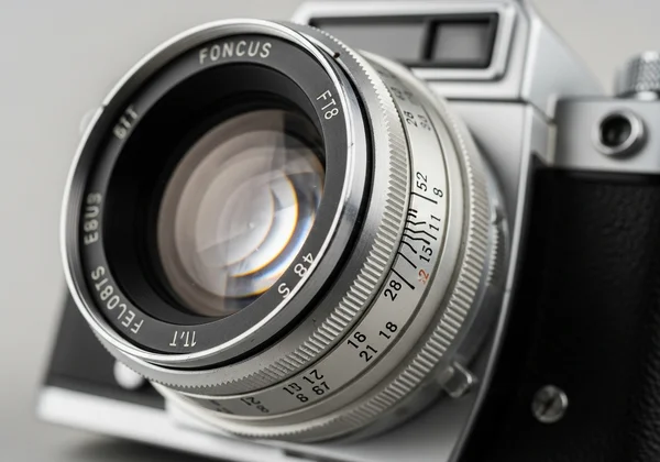 Vintage camera lens with depth of field markings visible.